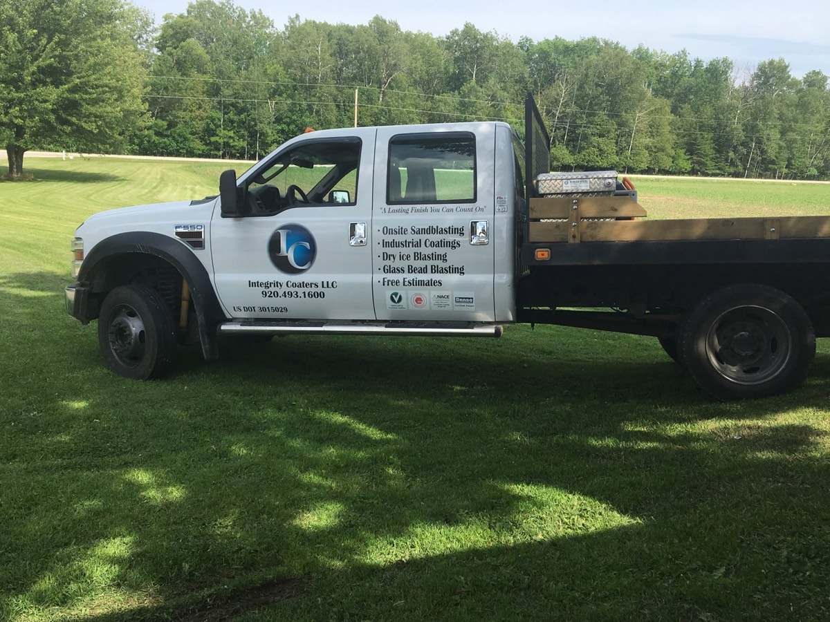 Integrity Coaters LLC branded flatbed service truck — onsite sandblasting and industrial coatings